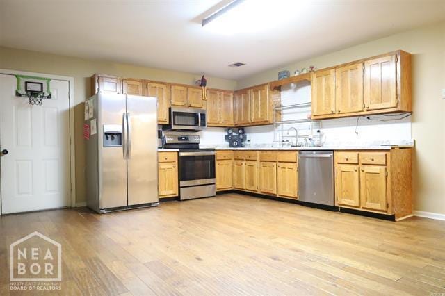 5703 Cedar St, Paragould, AR 72450 - kitchen featuring appliances with stainless steel finishes, light wood-style flooring, light countertops, and baseboards