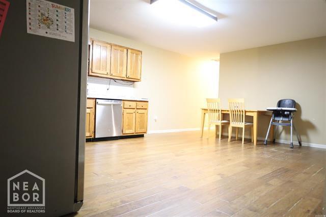 5703 Cedar St, Paragould, AR 72450 - kitchen featuring stainless steel appliances, baseboards, light wood-type flooring, and light brown cabinetry