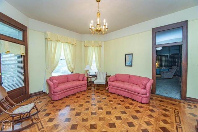 living area featuring a notable chandelier and baseboards