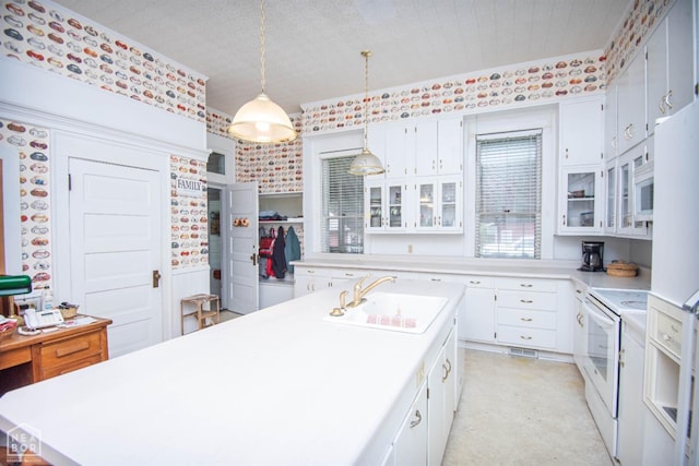 kitchen featuring light countertops, a sink, white appliances, and white cabinets
