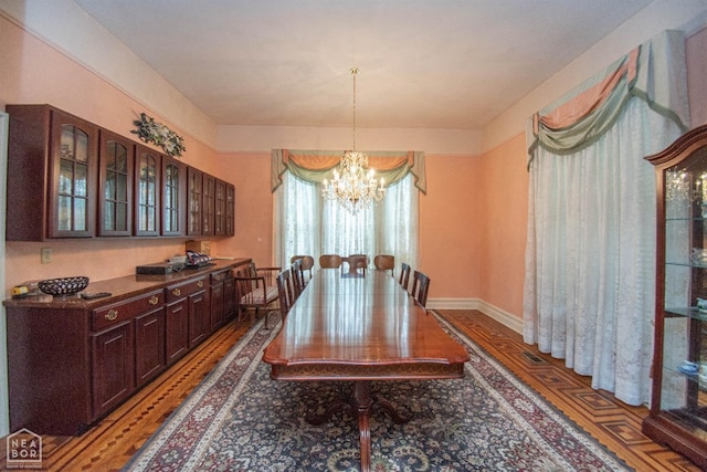 dining space with a notable chandelier and baseboards