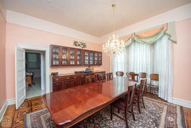 dining space with a notable chandelier and baseboards