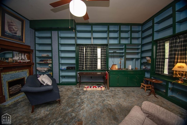living area with ceiling fan and a fireplace