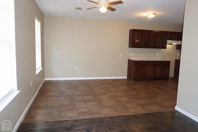 501 E Allen Dr, Jonesboro, AR 72401 - kitchen with ceiling fan, under cabinet range hood, baseboards, dark brown cabinetry, and light countertops