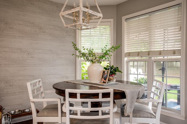 321 Crestfield Dr, Jonesboro, AR 72404 - dining room with wood walls, a chandelier, and plenty of natural light