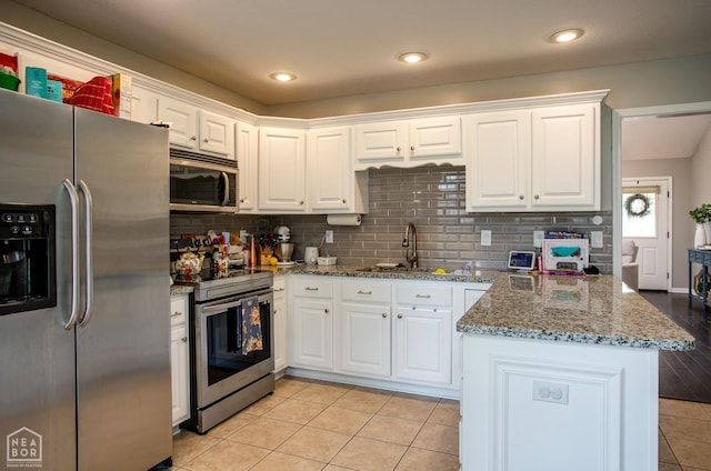 321 Crestfield Dr, Jonesboro, AR 72404 - kitchen with appliances with stainless steel finishes, a peninsula, white cabinets, decorative backsplash, and recessed lighting