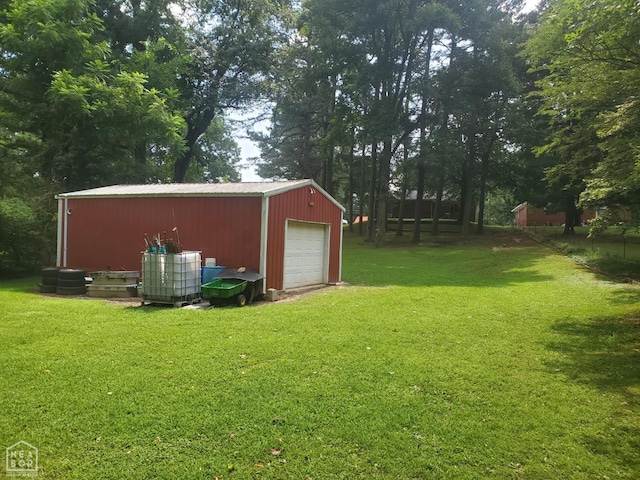 691 Crestline Dr, Piggott, AR 72454 - view of green lawn with a detached garage, an outdoor structure, and driveway