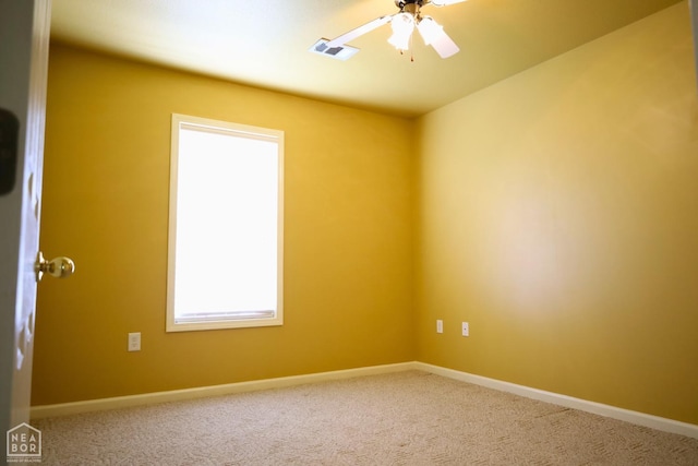spare room featuring carpet floors, a ceiling fan, and baseboards