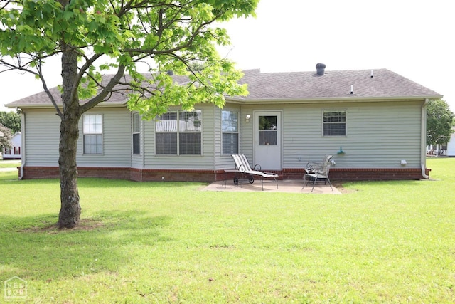 rear view of property featuring a patio, a yard, and roof with shingles