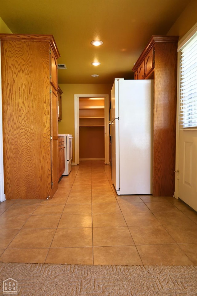 corridor with light tile patterned flooring and recessed lighting