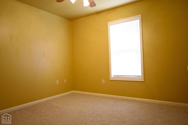 carpeted spare room with ceiling fan and baseboards
