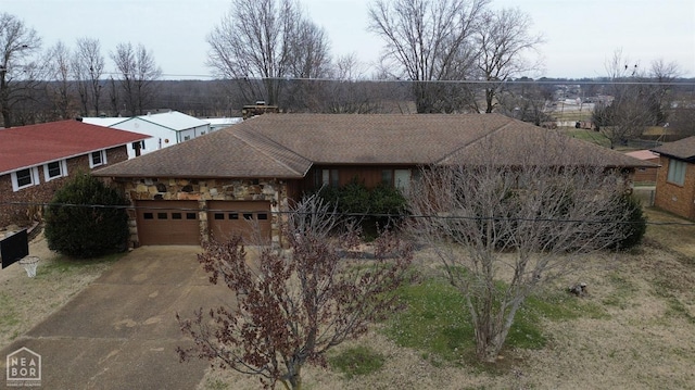 single story home featuring a garage, stone siding, and concrete driveway