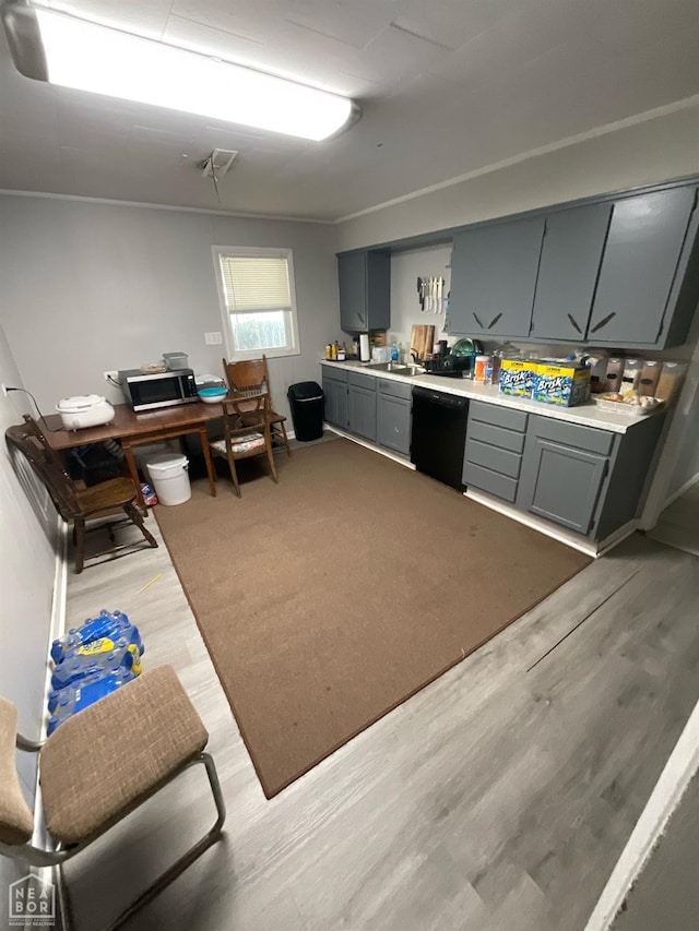 kitchen featuring light wood-style floors, gray cabinetry, dishwasher, and light countertops