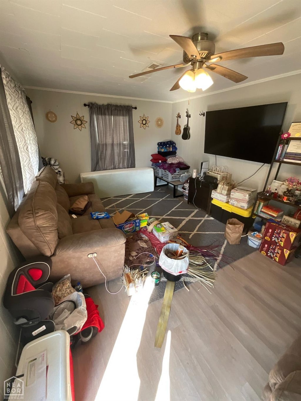 living area featuring crown molding, a ceiling fan, and wood finished floors