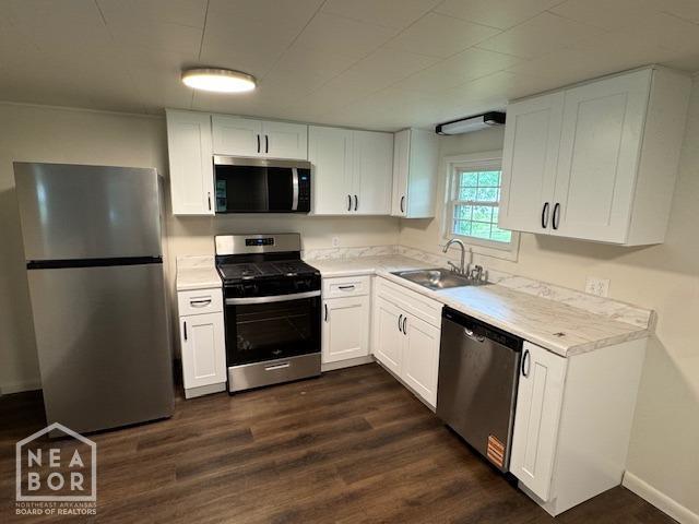 330 E Oak St E, Bono, AR 72416 - kitchen with stainless steel appliances, a sink, light countertops, white cabinets, and dark wood-style flooring