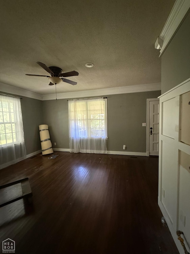 420 W Cherry Ave W, Jonesboro, AR 72401 - spare room with a textured ceiling, dark wood-style flooring, ornamental molding, ceiling fan, and baseboards