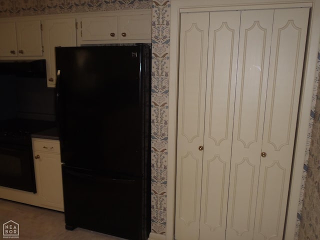 4 Virginia Rd, Newport, AR 72112 - kitchen featuring black appliances, range hood, white cabinetry, wallpapered walls, and dark countertops
