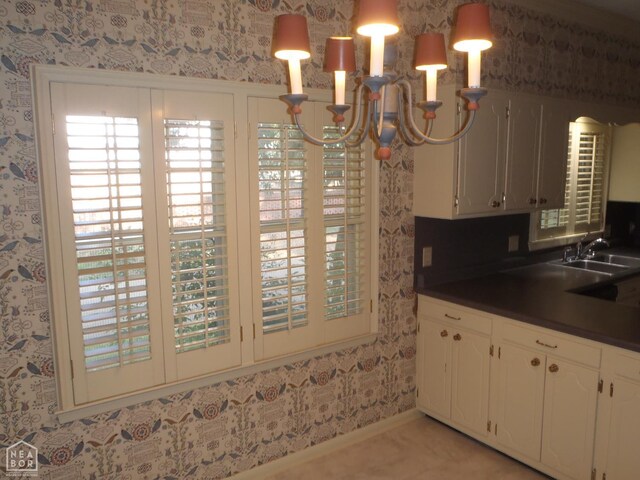 4 Virginia Rd, Newport, AR 72112 - kitchen with dark countertops, wallpapered walls, a chandelier, and white cabinets