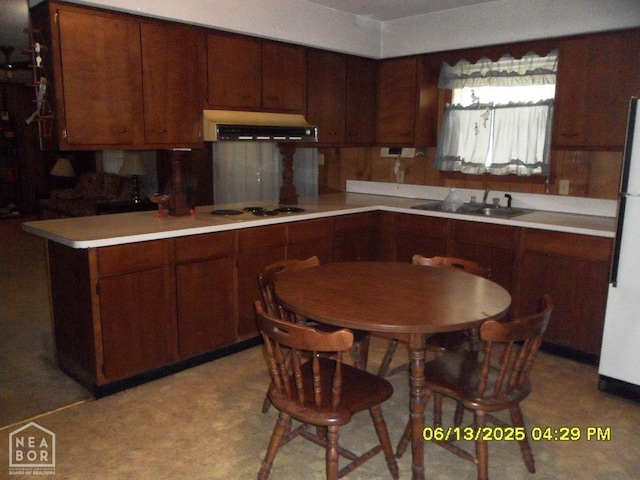 2805 Robinson St, Newport, AR 72112 - kitchen featuring wall chimney range hood, stovetop, freestanding refrigerator, light countertops, and light flooring