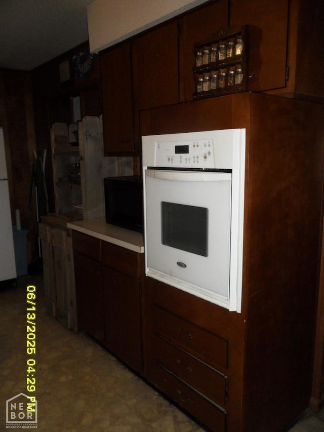 2805 Robinson St, Newport, AR 72112 - kitchen with white appliances, light countertops, and dark brown cabinetry