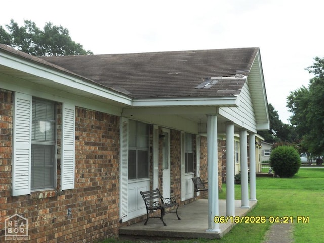 2805 Robinson St, Newport, AR 72112 - view of property exterior with a porch, a lawn, brick siding, and roof with shingles