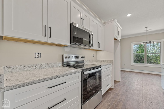 kitchen with light stone countertops, white cabinetry, crown molding, stainless steel appliances, and light wood-type flooring