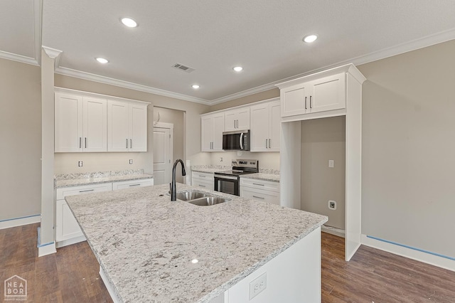 kitchen with visible vents, a sink, crown molding, stainless steel appliances, and an island with sink
