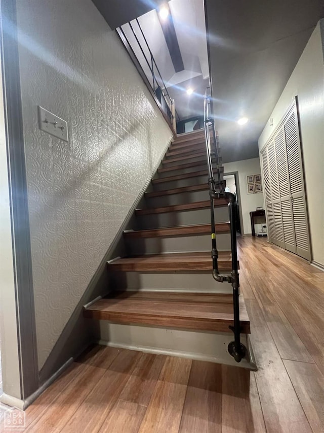 staircase with baseboards and wood finished floors