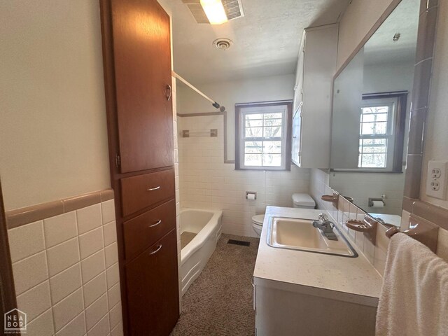 245 S 18th St, Piggott, AR 72454 - bathroom with toilet, vanity, visible vents, and tile walls