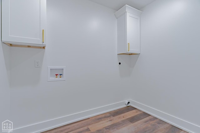 400 Gia St, Bono, AR 72416 - laundry area with washer hookup, cabinet space, and wood finished floors
