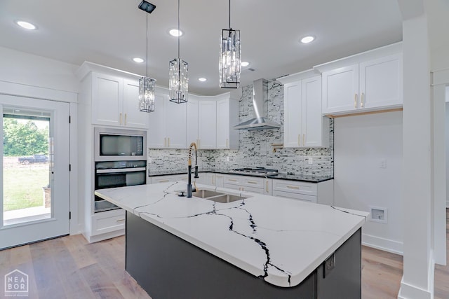 400 Gia St, Bono, AR 72416 - kitchen featuring stainless steel appliances, wall chimney range hood, light wood finished floors, decorative backsplash, and recessed lighting