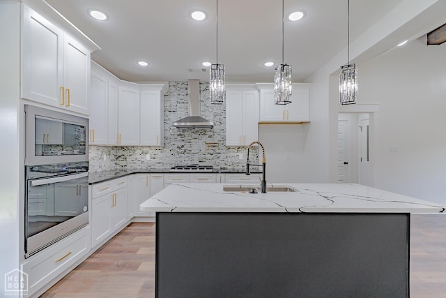 400 Gia St, Bono, AR 72416 - kitchen with appliances with stainless steel finishes, wall chimney range hood, light wood-type flooring, tasteful backsplash, and recessed lighting