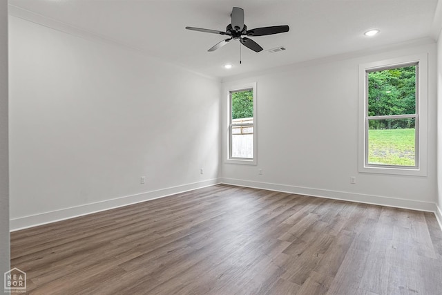3424 Hudson Dr, Jonesboro, AR 72405 - empty room featuring dark wood-type flooring, visible vents, a ceiling fan, and a healthy amount of sunlight