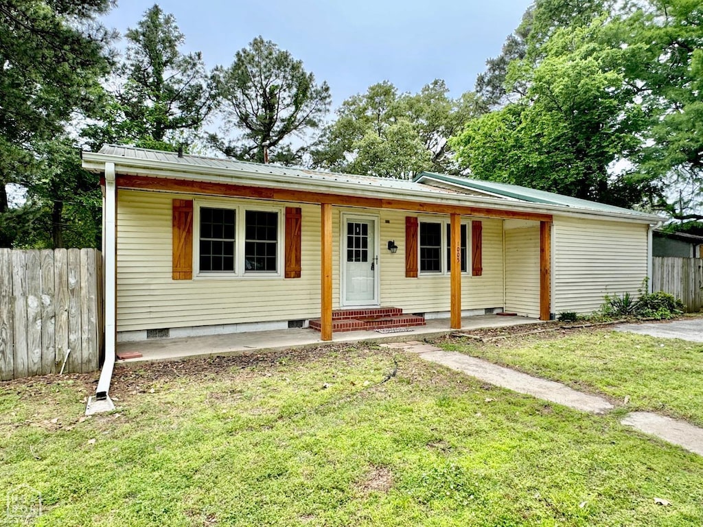 view of front of house featuring fence, metal roof, covered porch, crawl space, and a front lawn