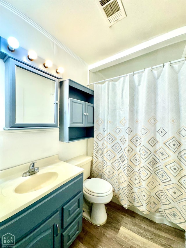 1005 W Lake St, Manila, AR 72442 - full bathroom featuring wood finished floors, toilet, vanity, ornamental molding, and curtained shower
