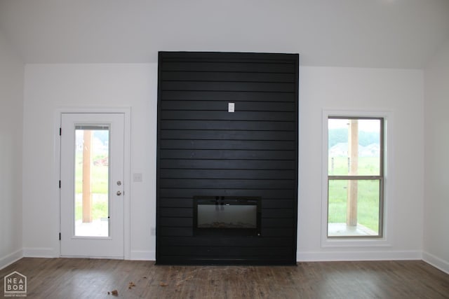 1816 N Oak, Brookland, AR 72417 - unfurnished living room featuring baseboards, wood finished floors, and a large fireplace