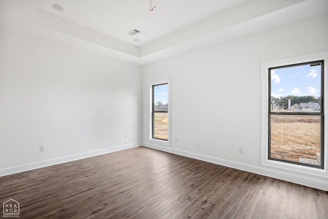 1816 N Oak, Brookland, AR 72417 - unfurnished room with dark wood-style flooring, baseboards, and a raised ceiling