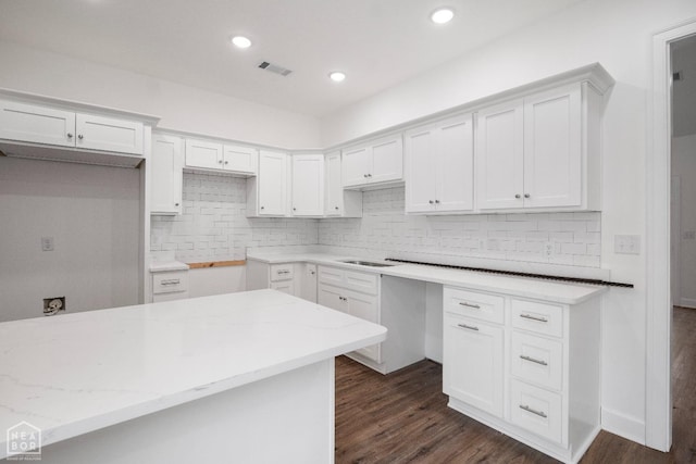 1816 N Oak, Brookland, AR 72417 - kitchen featuring backsplash, dark wood-style flooring, light stone counters, white cabinetry, and recessed lighting