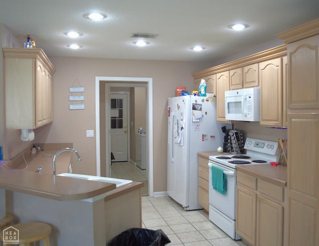 3300 Jeridon Cv, Jonesboro, AR 72404 - kitchen featuring white appliances, light brown cabinets, a peninsula, a kitchen bar, and light tile patterned flooring
