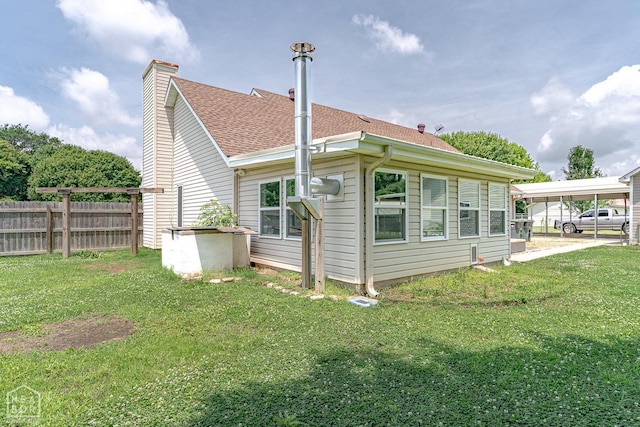 13326 Dixie Ln, Trumann, AR 72472 - rear view of house with roof with shingles, a chimney, and a detached carport