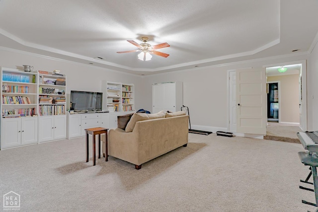 13326 Dixie Ln, Trumann, AR 72472 - living room featuring a tray ceiling, light carpet, ceiling fan, ornamental molding, and built in shelves