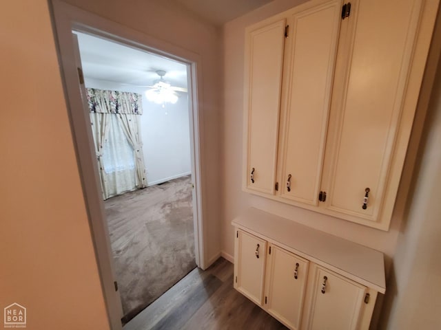 hallway featuring baseboards and wood finished floors