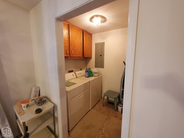 laundry room featuring electric panel, separate washer and dryer, and cabinet space