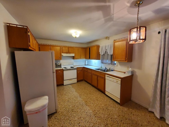 kitchen featuring white appliances, under cabinet range hood, light countertops, a sink, and brown cabinets