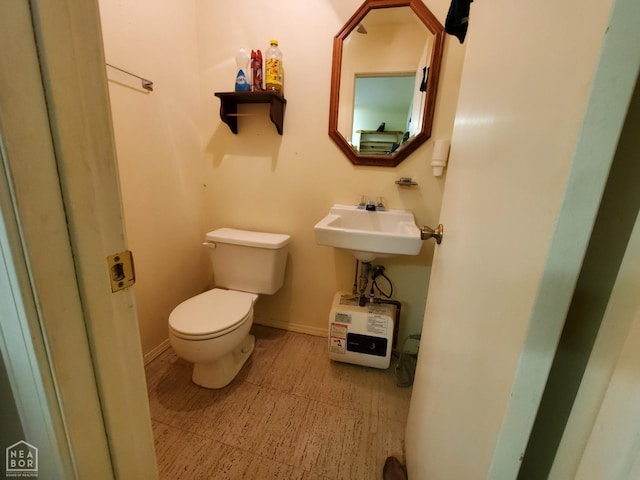 bathroom featuring baseboards and toilet