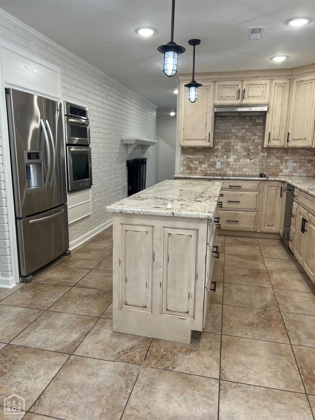 318 Davis St, Manila, AR 72442 - kitchen featuring stainless steel appliances, backsplash, a center island, light stone counters, and recessed lighting