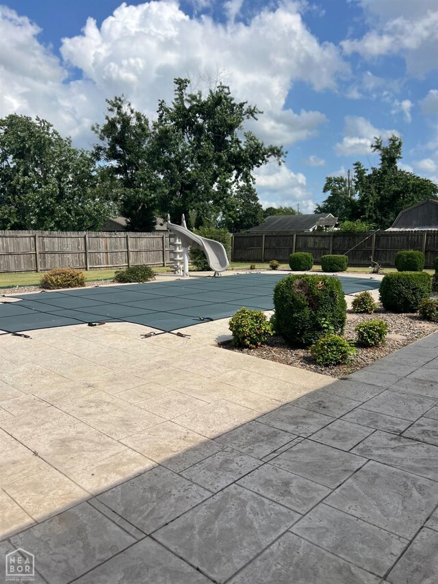 318 Davis St, Manila, AR 72442 - view of pool featuring a water slide, a fenced backyard, and a patio area