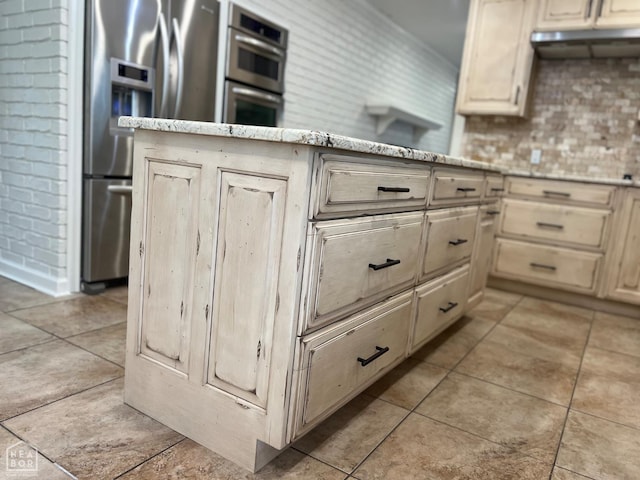 318 Davis St, Manila, AR 72442 - kitchen featuring stainless steel appliances, light tile patterned flooring, light stone countertops, tasteful backsplash, and light brown cabinets