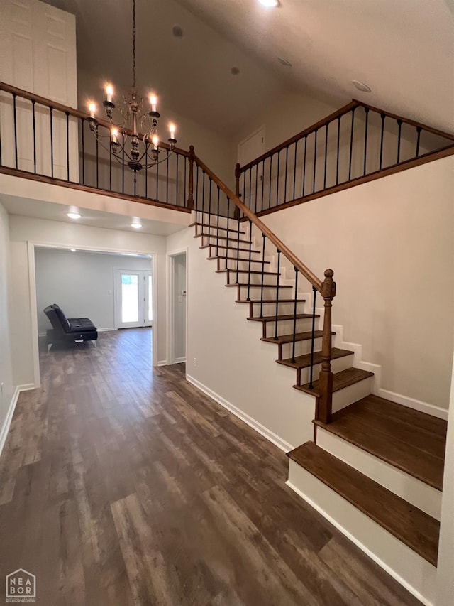 318 Davis St, Manila, AR 72442 - staircase with high vaulted ceiling, a chandelier, and wood finished floors