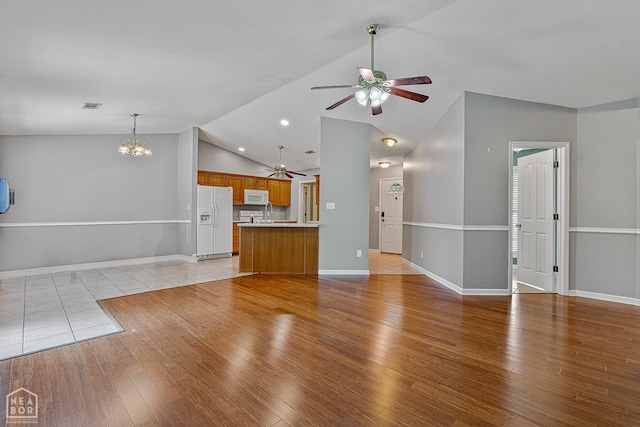 214 Holmes Rd, Jonesboro, AR 72405 - unfurnished living room featuring a ceiling fan, lofted ceiling, a chandelier, and light wood-style floors
